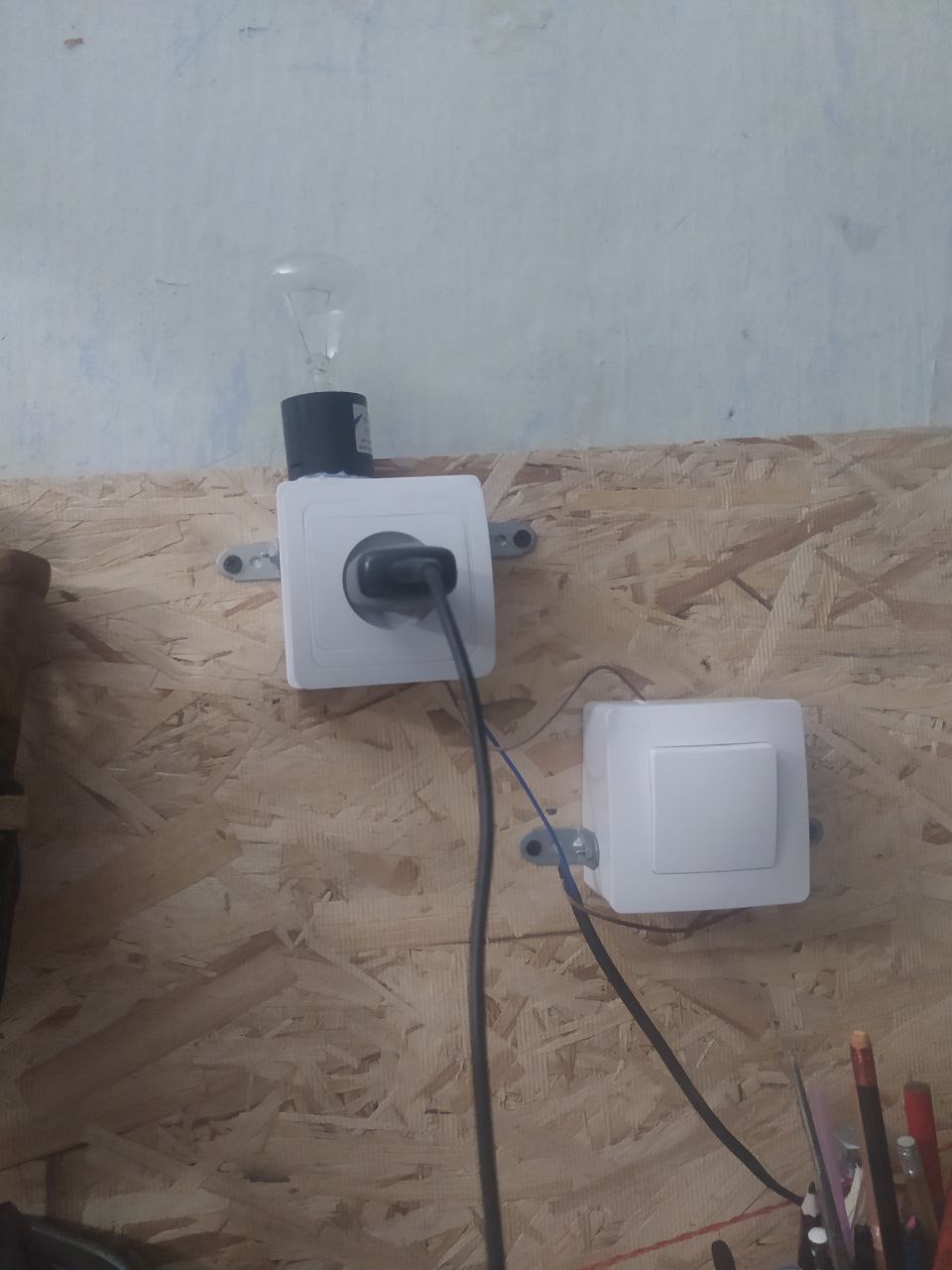 Лампочка, подключенная последовательно с разеткой.